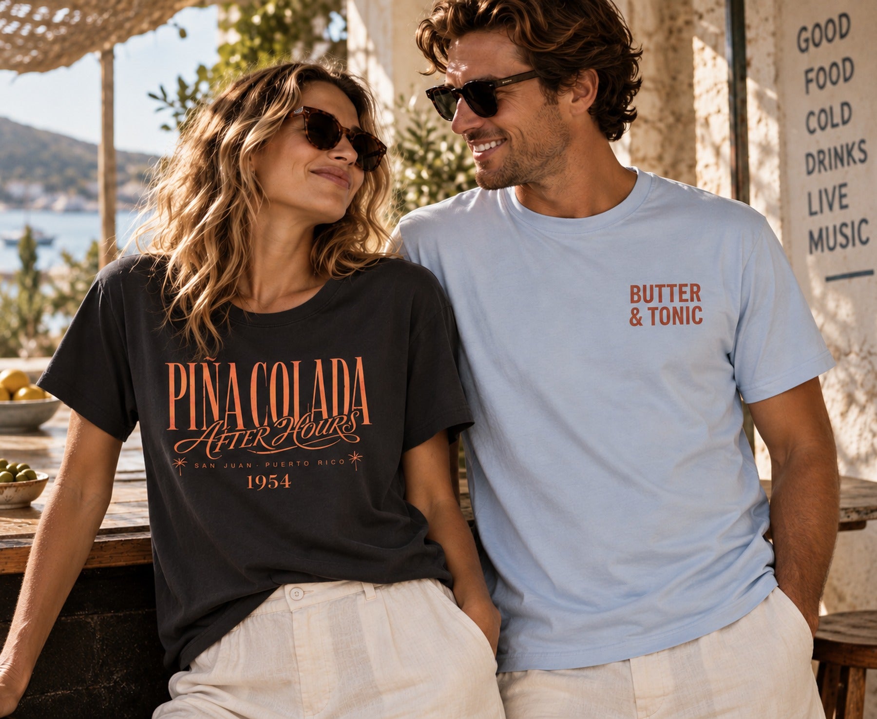 Woman wearing a Butter & Tonic logo tee at a sunlit bar